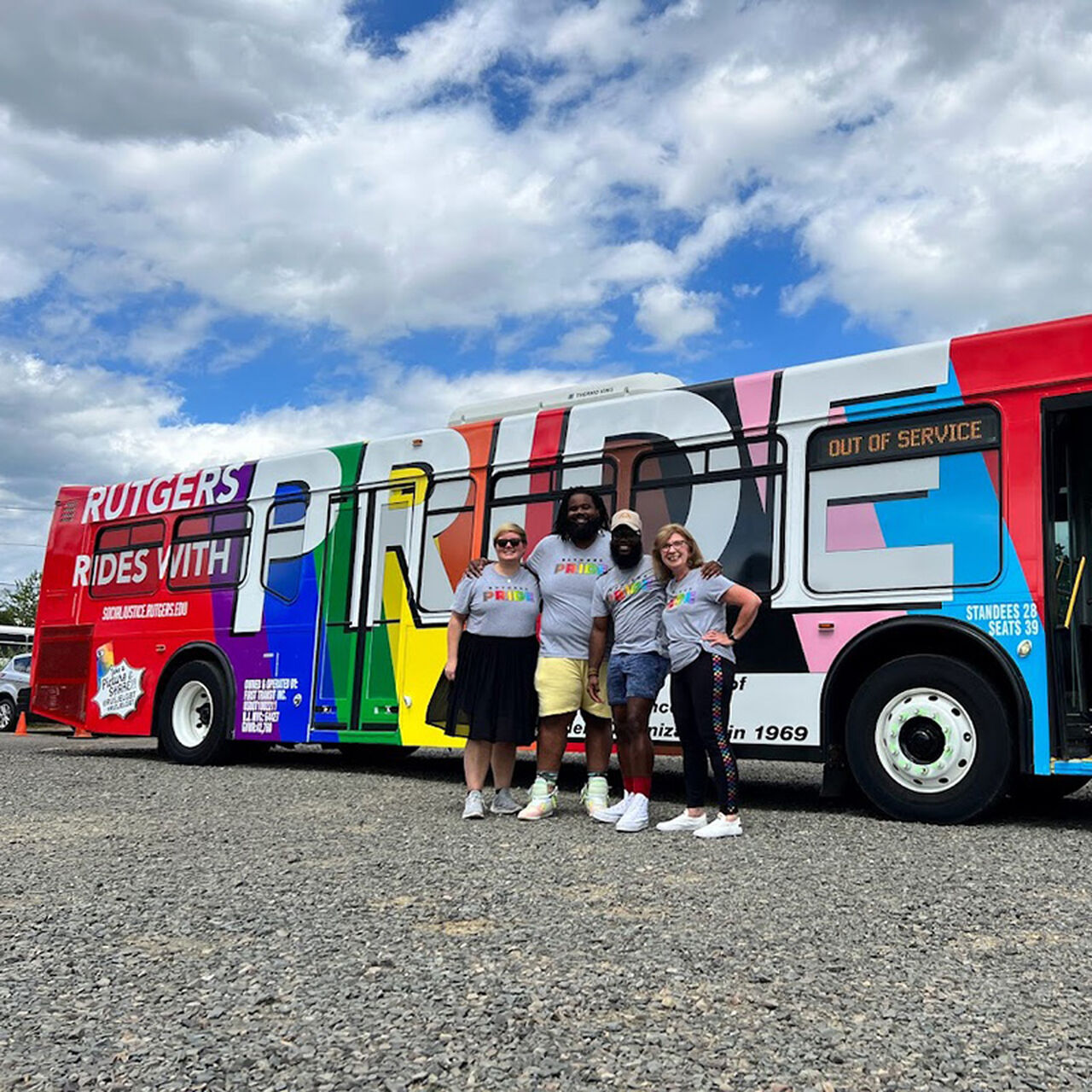 Group of students standing in front of a Pride bus image number 0