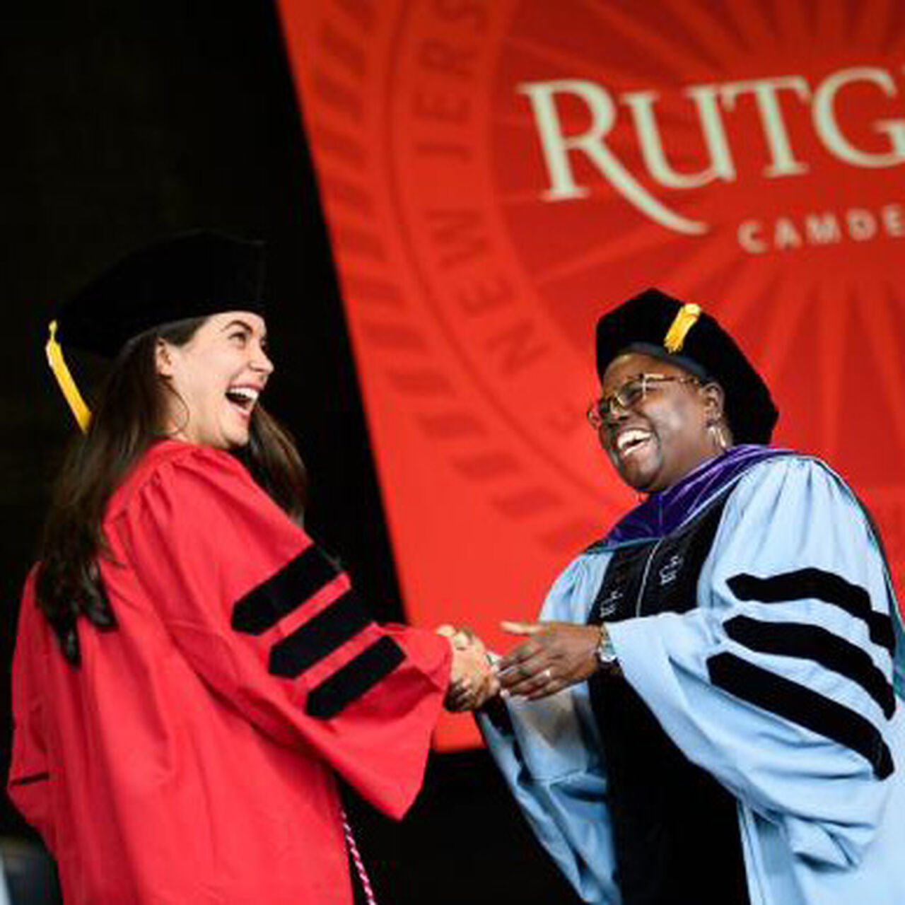 Rutgers professor giving degree to student at graduation image number 0