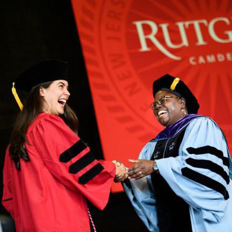 Rutgers professor giving degree to student at graduation