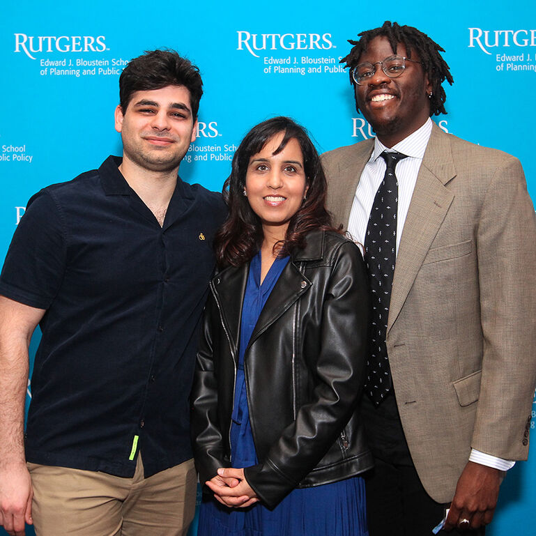 Three people standing in front of blue background