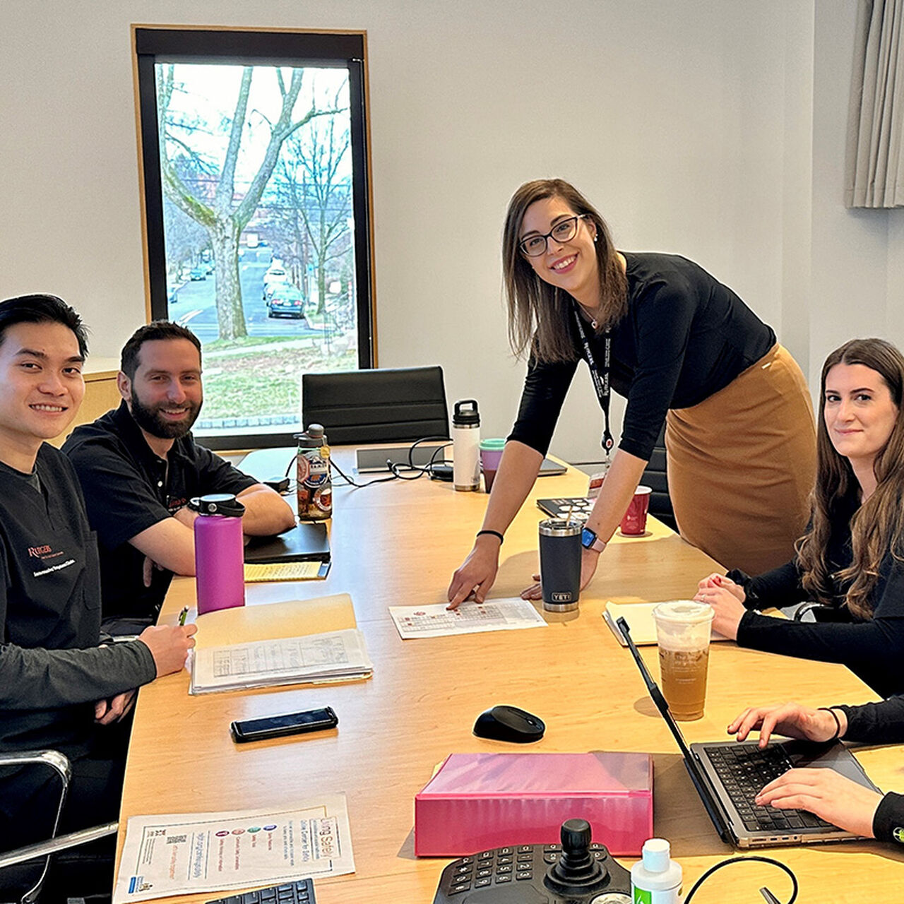 Practitioners on the RCAAS IOC team sitting around a table and smiling at the camera image number 0