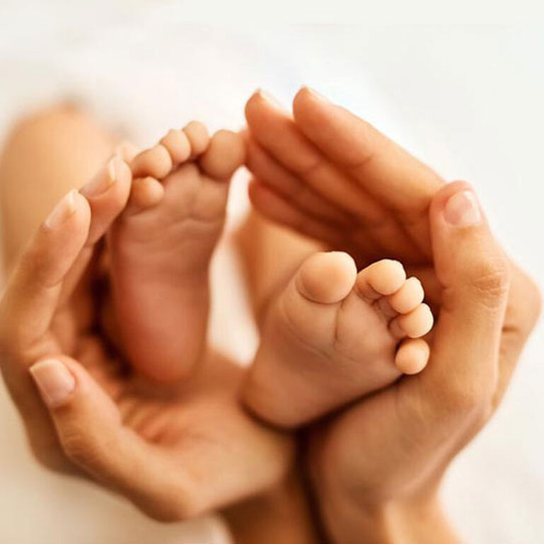 Hands cupping babies feet