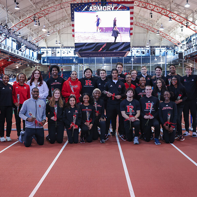 Track and field team standing together for a picture on an indoor track