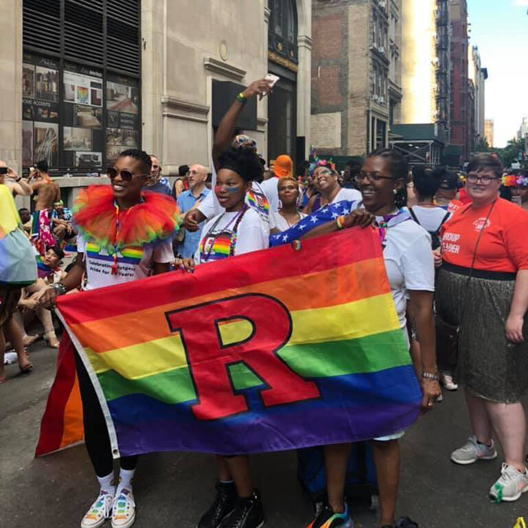 Rutgers community members marching in the New York Pride Parade holding a Rutgers pride banner