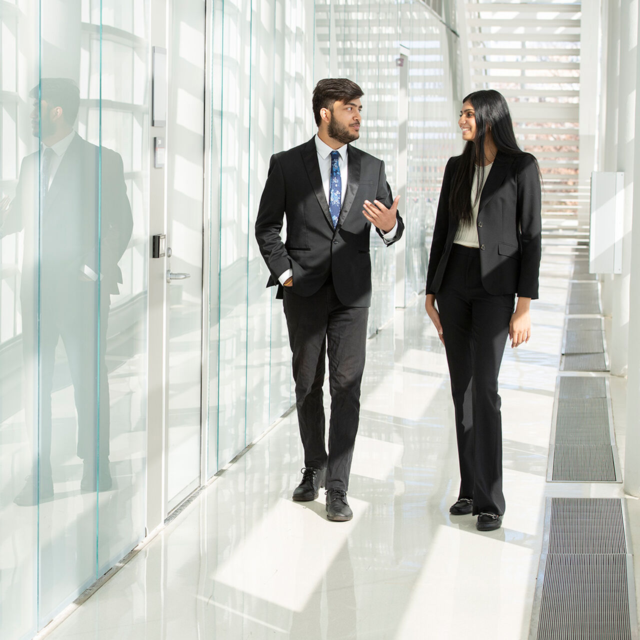 Two students in professional attire walking down a hallway in a Rutgers Business School building image number 0