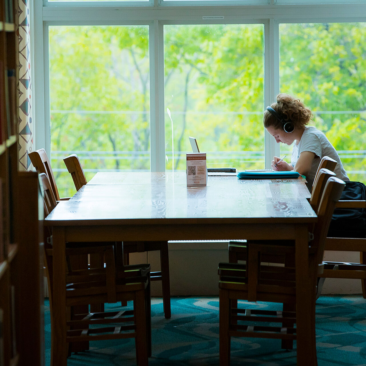Student working at a table in the Alexander Library image number 0