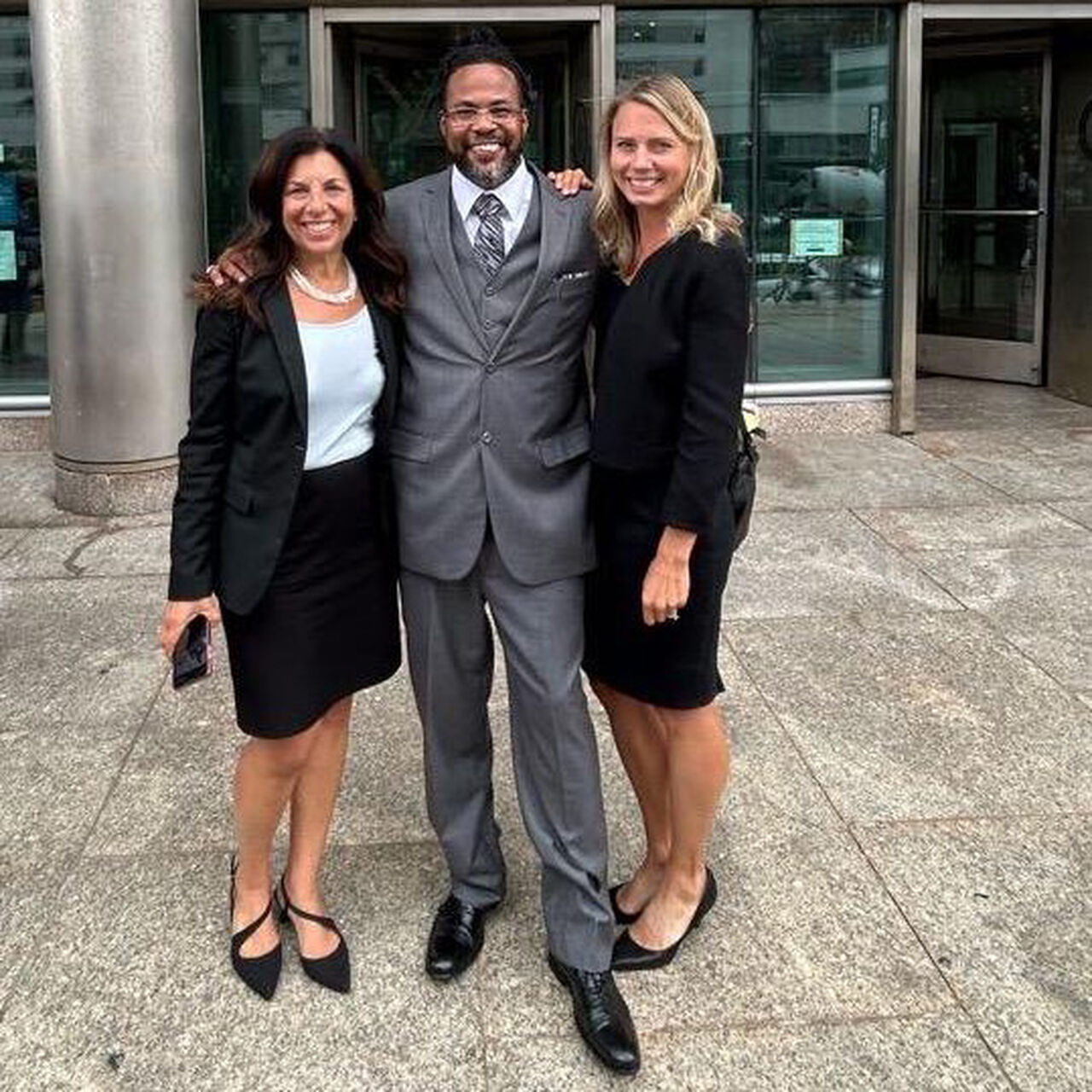 Innocence Project team members standing and smiling with an exonerated person. image number 0