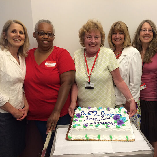 Group of women standing around birthday cake image number 0