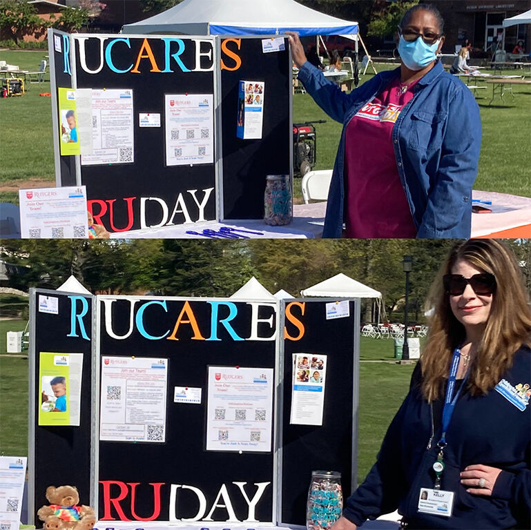 People outside at a folding table standing next to an RUCARES trifold board