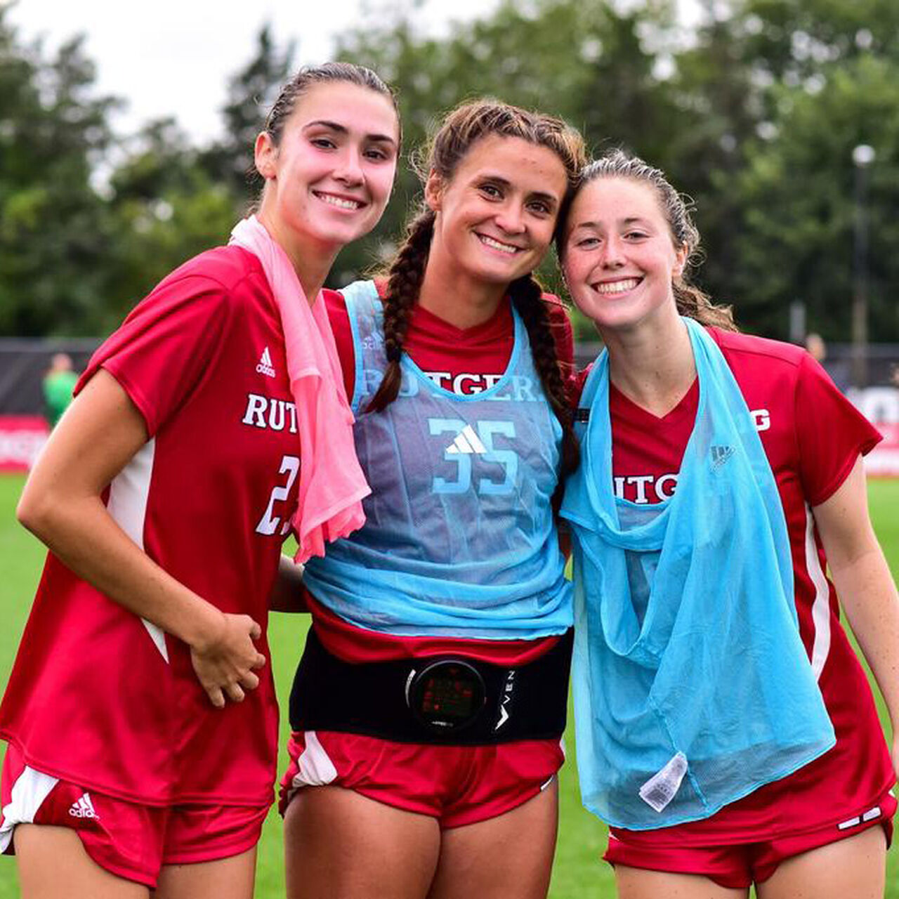 Three Rutgers Women's Soccer players smiling for the camera on the field image number 0