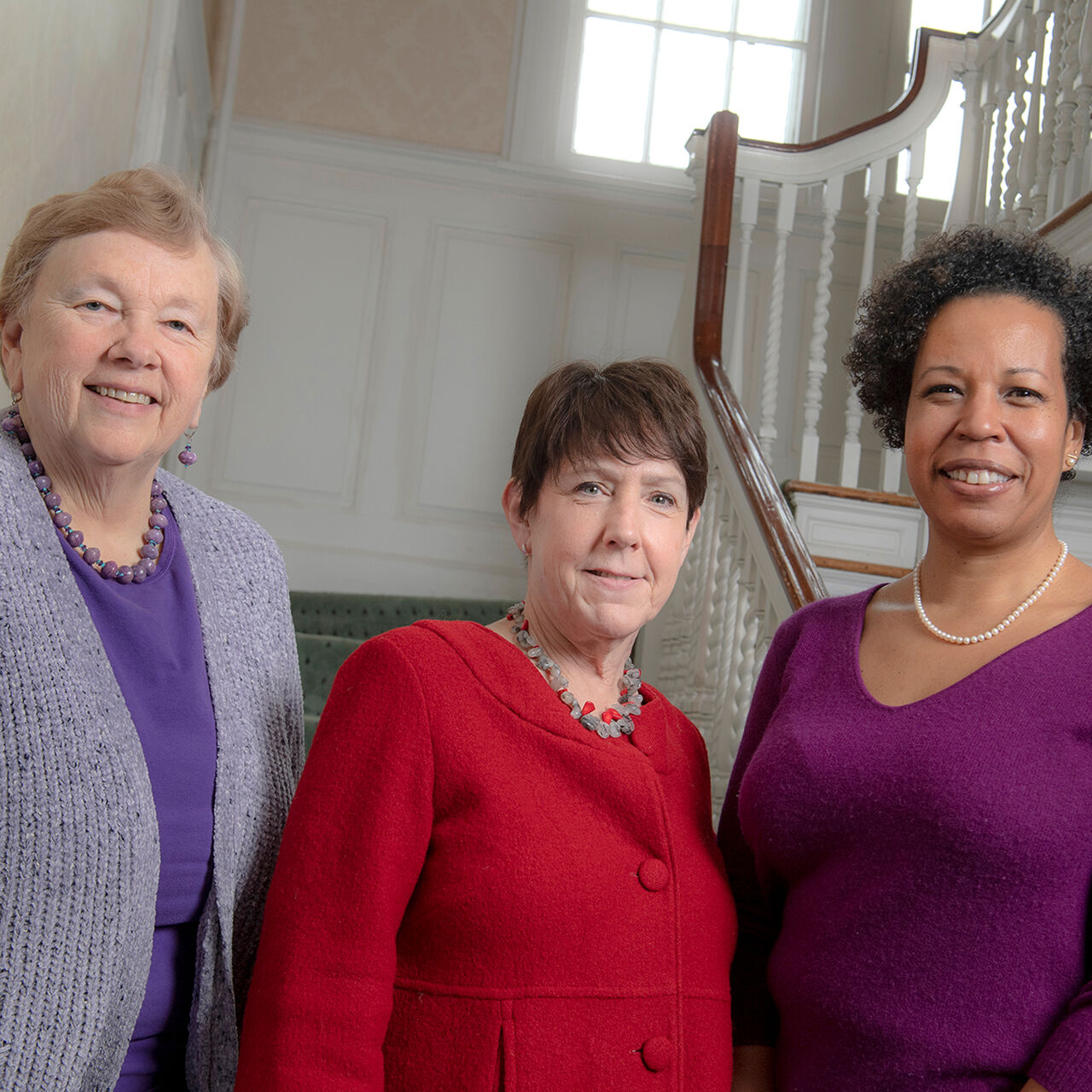 Three staff members standing on a staircase smiling in the Eagleton Institute of Politics building image number 0