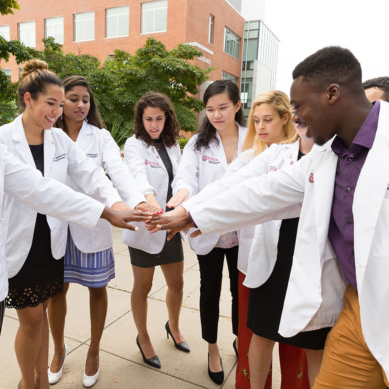 Medical school students standing in a circle with their hands together image number 0