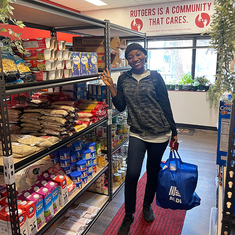 Student standing in the Scarlet Raptor's Nest pantry at Rutgers Camden.