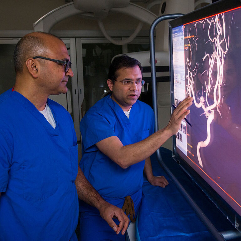Two neurosurgeons examining an image