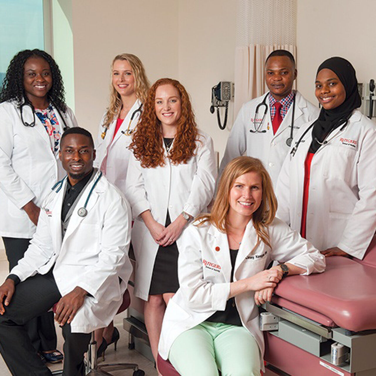 Group of nursing students in white coats smiling at the camera image number 0