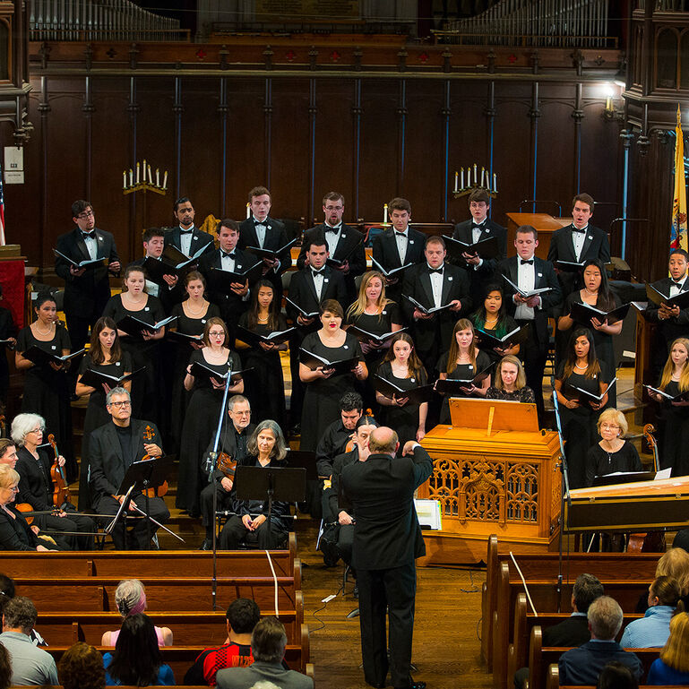 A choir of singers performing in Kirkpatrick Chapel on the Old Queens campus