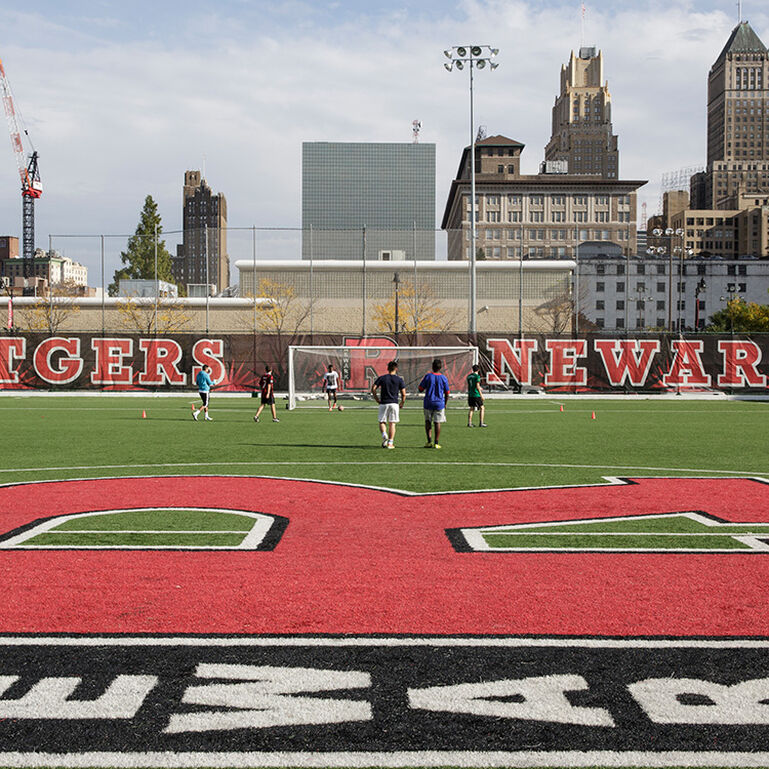 A group of students playing soccer on the field at Rutgers-Newark