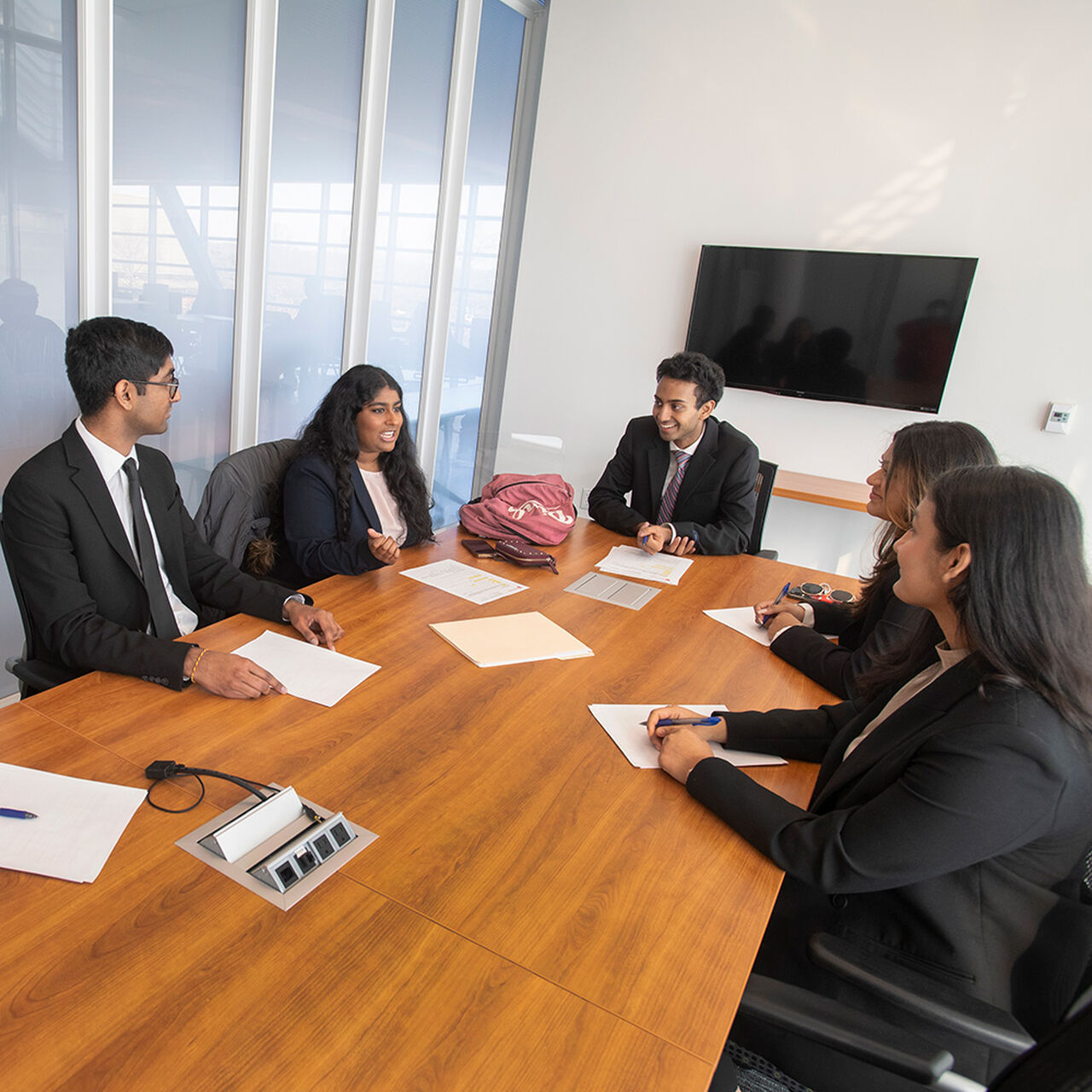 Group of RBS students in professional attire sitting around a conference table image number 0