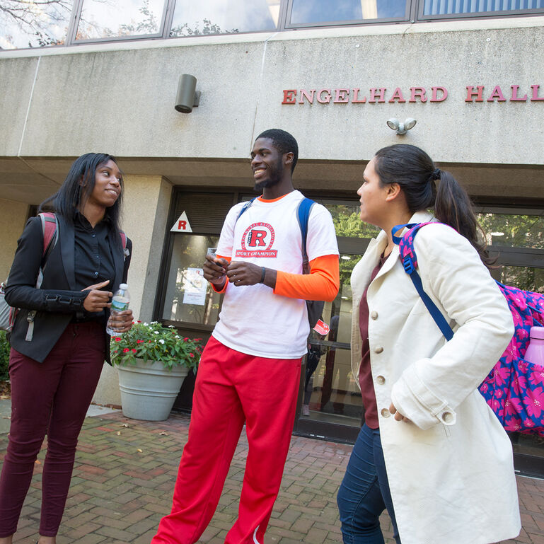 3 students standing and talking in front of Engelhard Hall at Rutgers-Newark