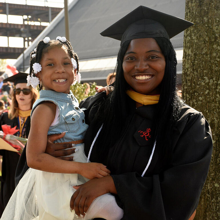 Graduate student holding a small child