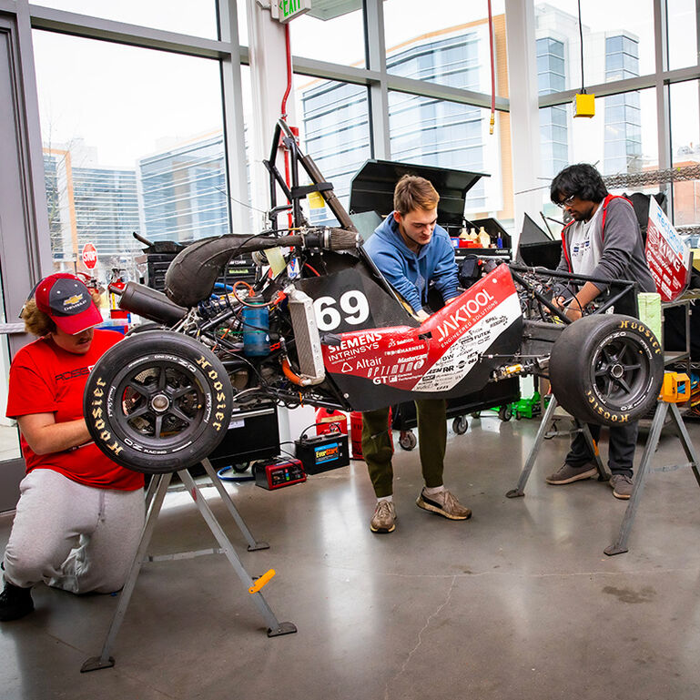 Three students working on racecar