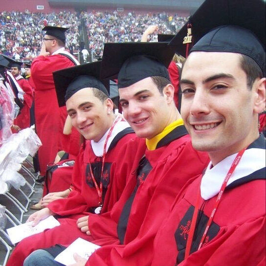 Yesner at graduation in regalia with friends image number 2