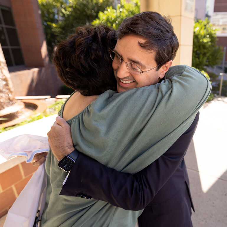 Two smiling people hugging