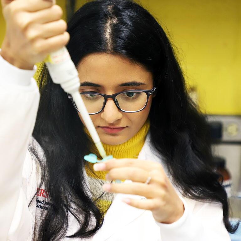 Student pipetting a sample in an Robert Wood Johnson Medical School laboratory