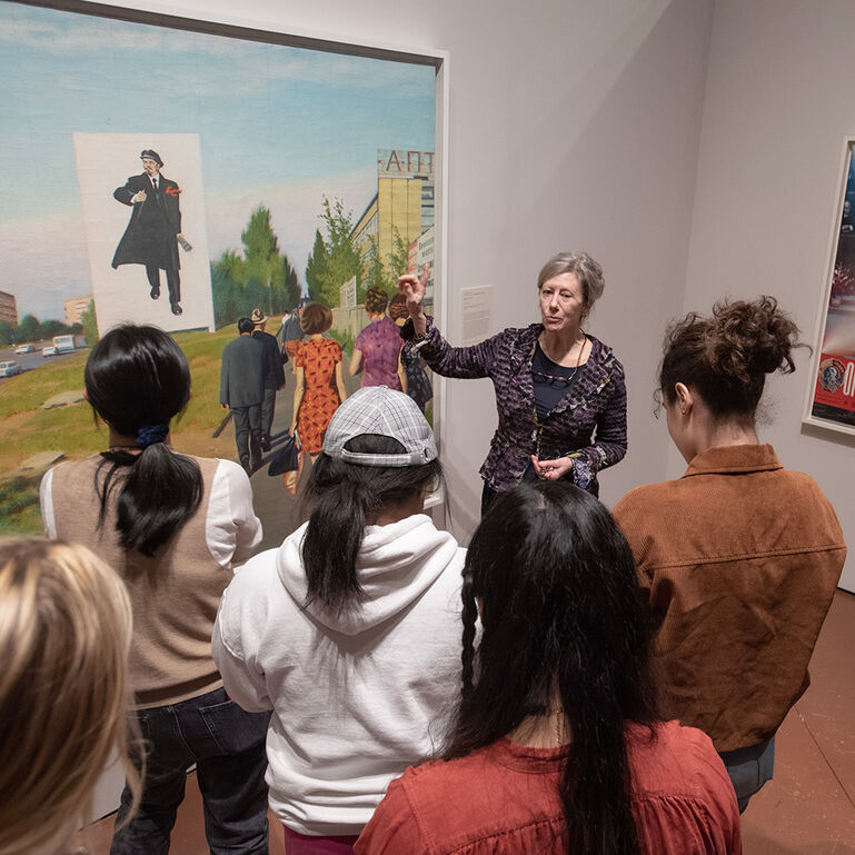 Professor talking to a group of students in front of a painting in the Zimmerli Museum Upper Dodge Gallery
