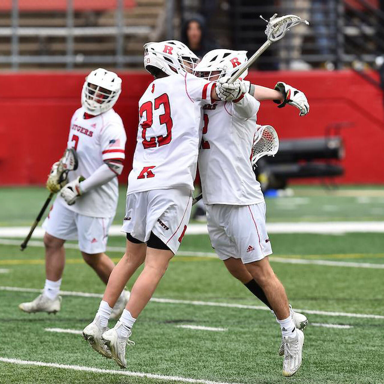 Two Men's Lacrosse players in gear chest bumping on the field image number 0