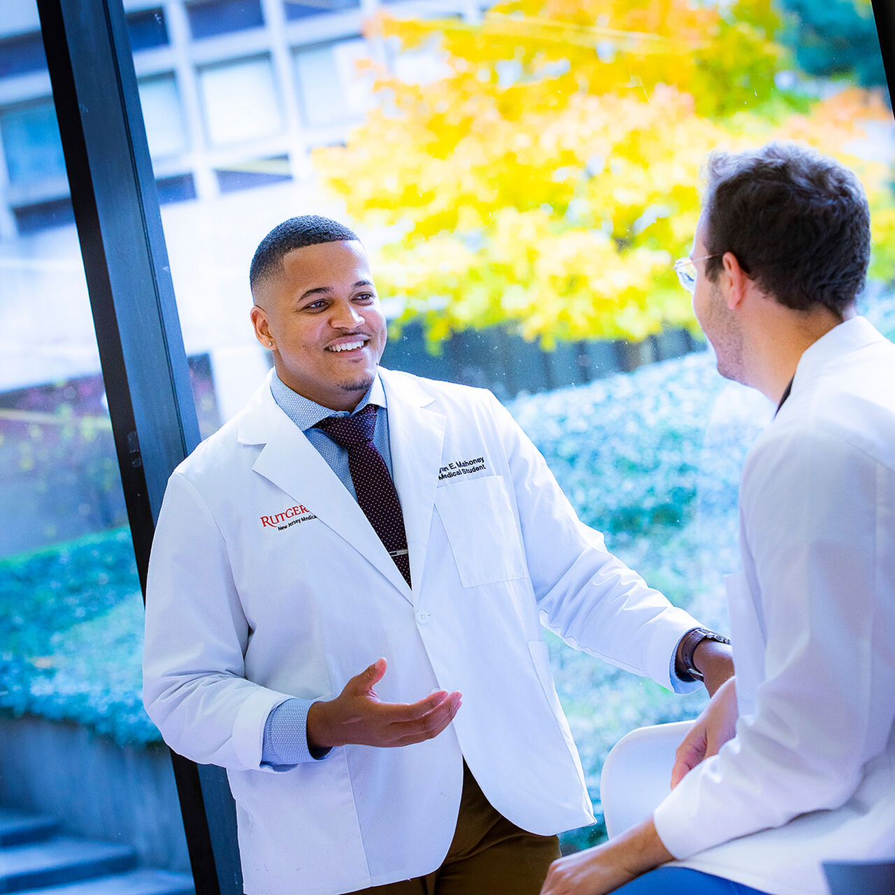 New Jersey Medical School student chatting with a colleague in a medical facility image number 0