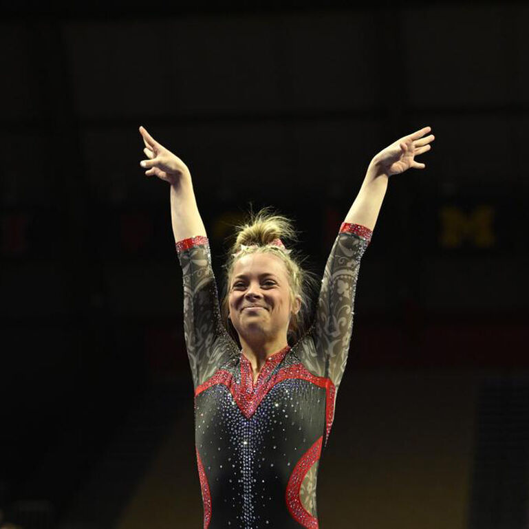 Rutgers Gymnastics team member holding her arms over her air during a routine